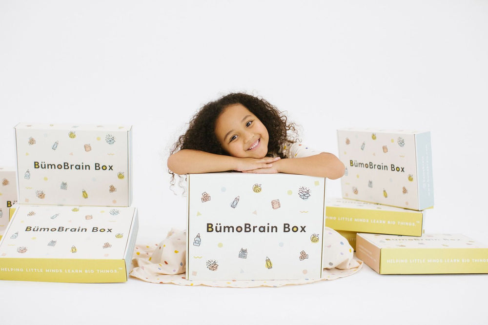 Girl resting arms and face on bümo box.